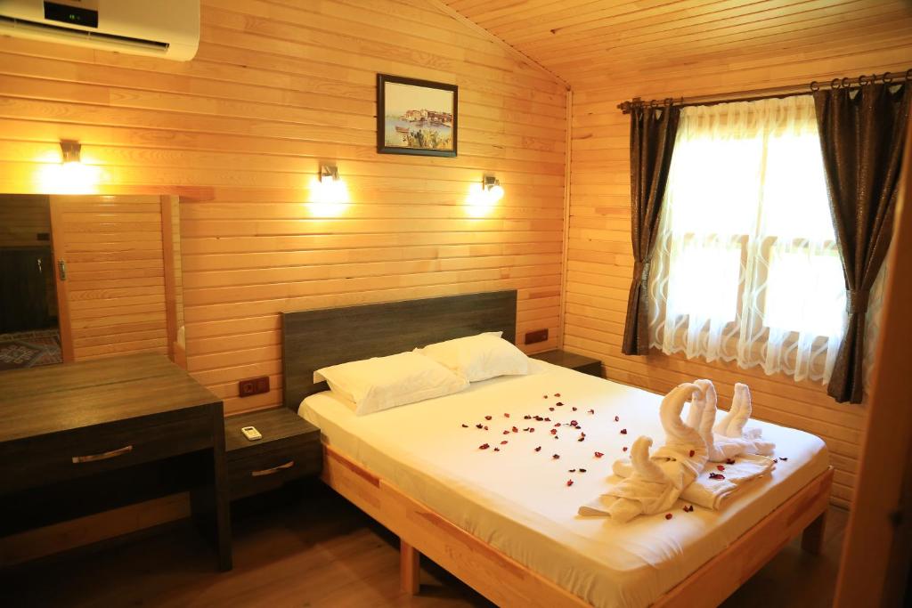un dormitorio con una cama con dos animales de peluche en Tunays Pansiyon, en Cıralı