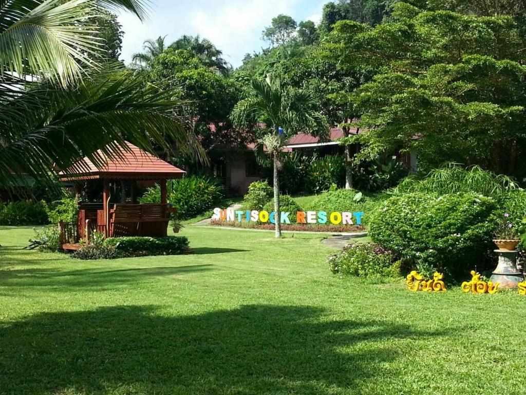 a park with a gazebo and flowers in the grass at Suntisook Resort in Ko Yao Noi