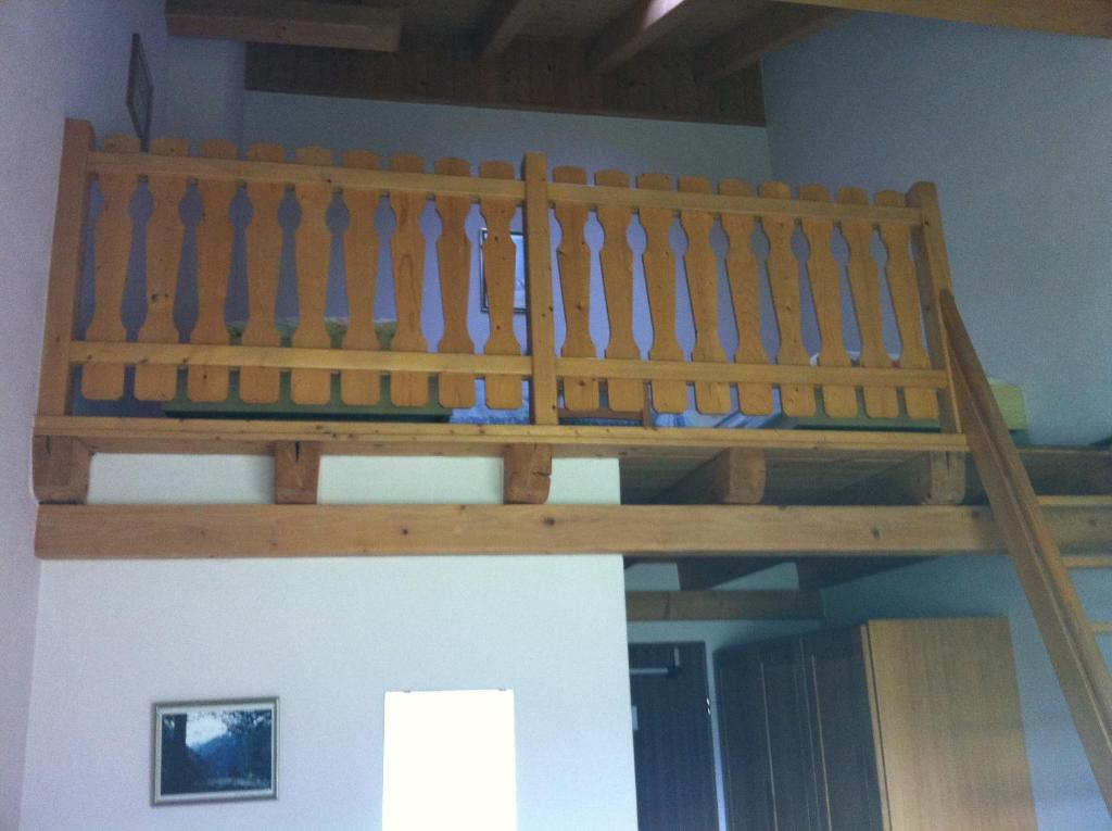 a wooden loft bed in a room at Hotel Pizzeria Selva in Zernez