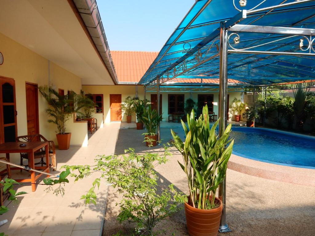 a patio with a swimming pool and a house with plants at Baan Malee in Ban Tha Sao Kradong