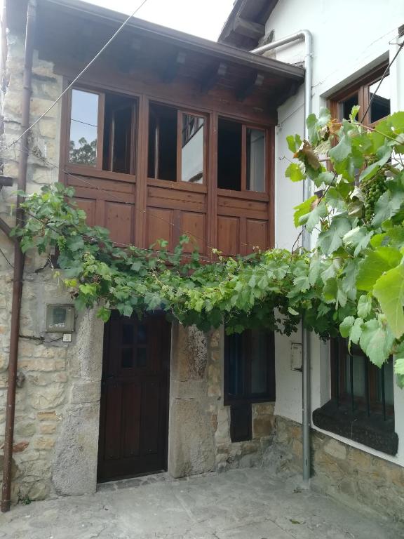a house with a wooden door and some plants at La Casina de Felix in Alles