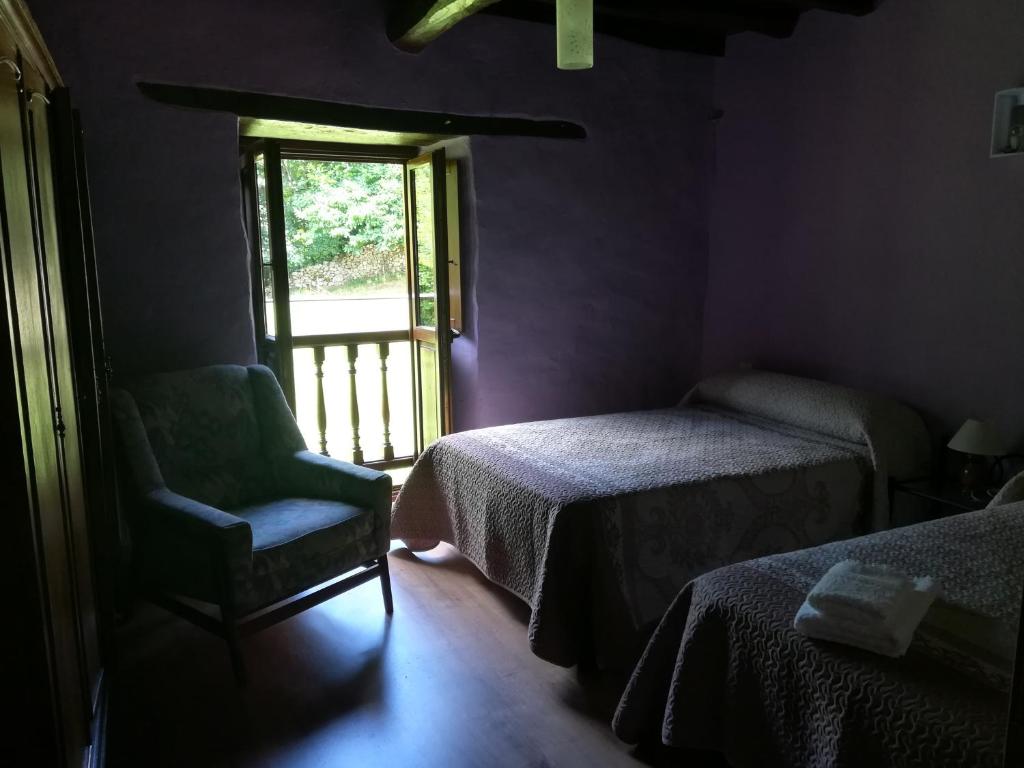 um quarto com duas camas e uma cadeira e uma janela em La Casina de Felix em Alles