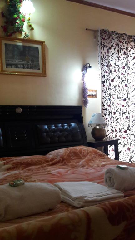 a bed with two pillows on it in a bedroom at Blooming Dale Hotel in Srinagar