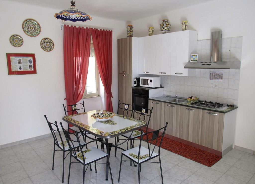 een keuken en eetkamer met een tafel en stoelen bij Casa del Barocco Caltagirone in Caltagirone