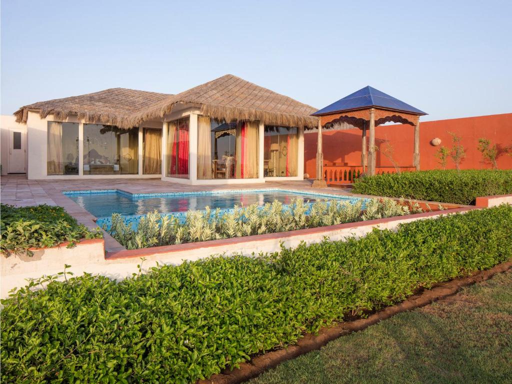 a house with a swimming pool and a gazebo at Serena Beach Resort in Mandvi