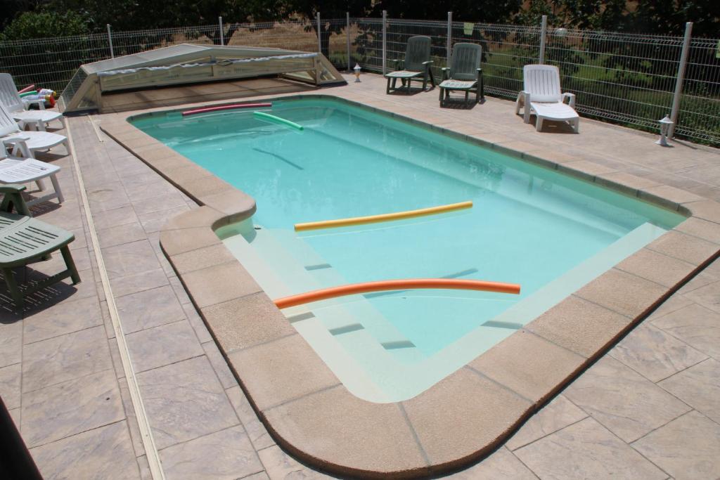 an empty swimming pool with chairs at La Maison du Soleil in Saint-Gaudéric