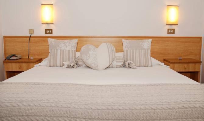 uma grande cama branca com duas almofadas em Albergo Centrale em Santo Stefano di Cadore
