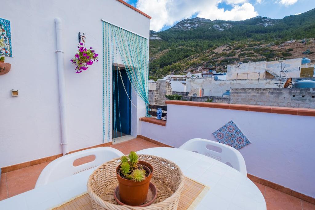 a table and chairs on a balcony with a potted plant at Giulia e Pietro - Marettimo Apartments in Marettimo