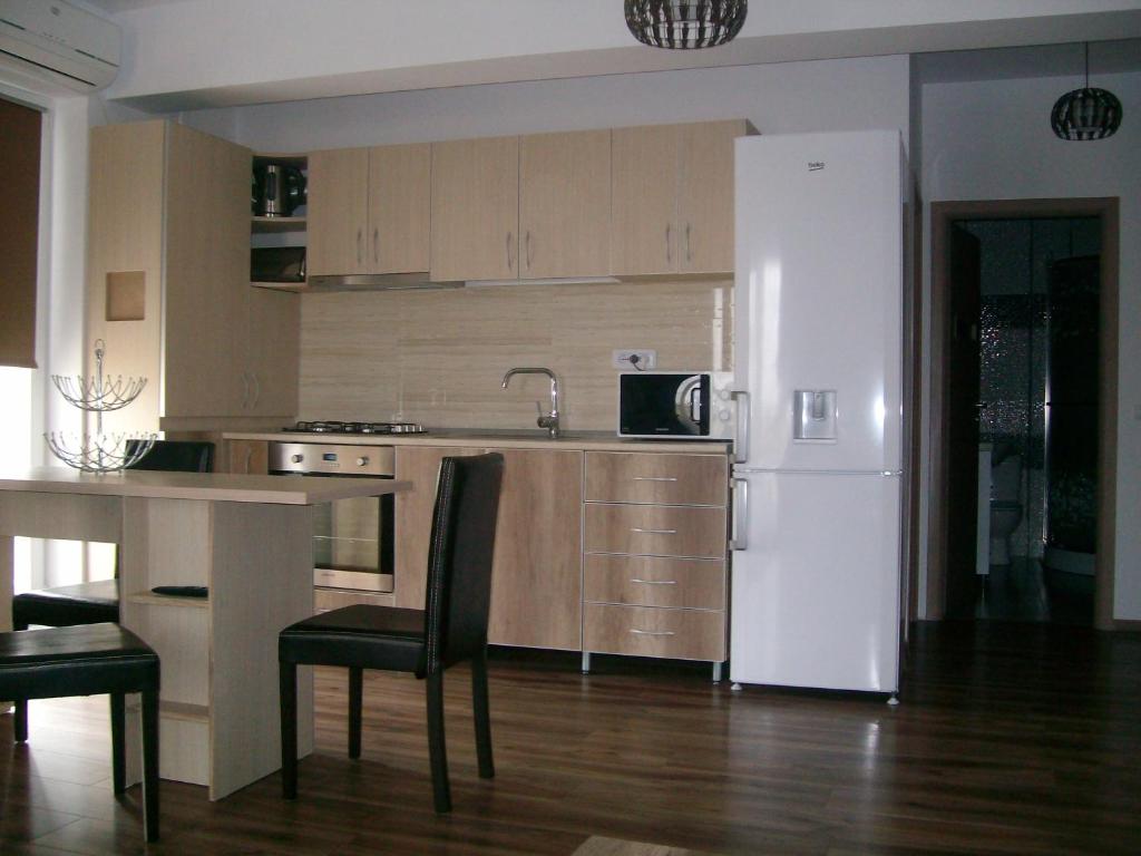 ママイア・ノルドにあるCosy Apartmentのキッチン(白い冷蔵庫、テーブル、椅子付)