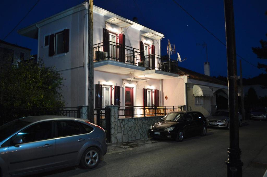 two cars parked in front of a house at night at Captain's House in Meganisi