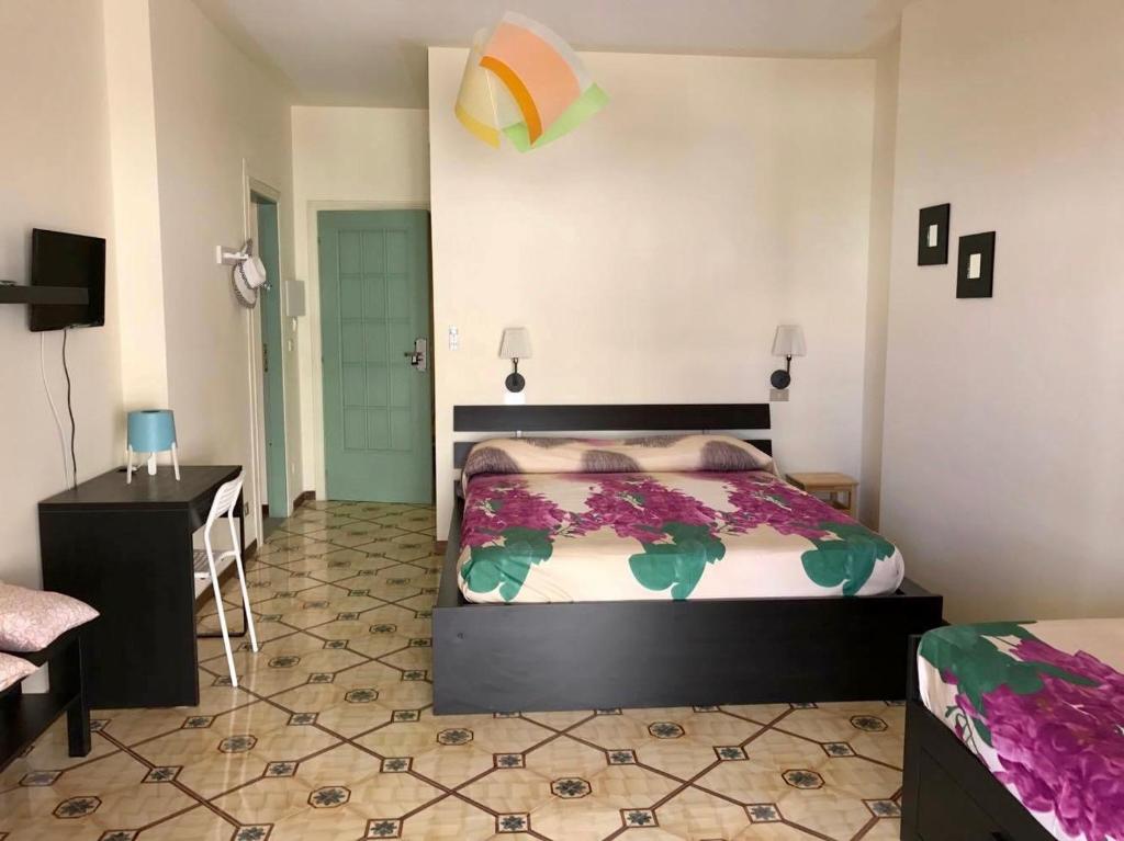een slaapkamer met een bed, een dressoir en een bureau bij AmoRosita in Diamante