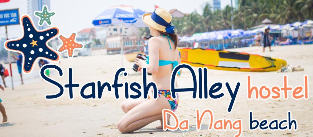 a woman in a hat sitting on the beach at Starfish Alley Hostel in Da Nang