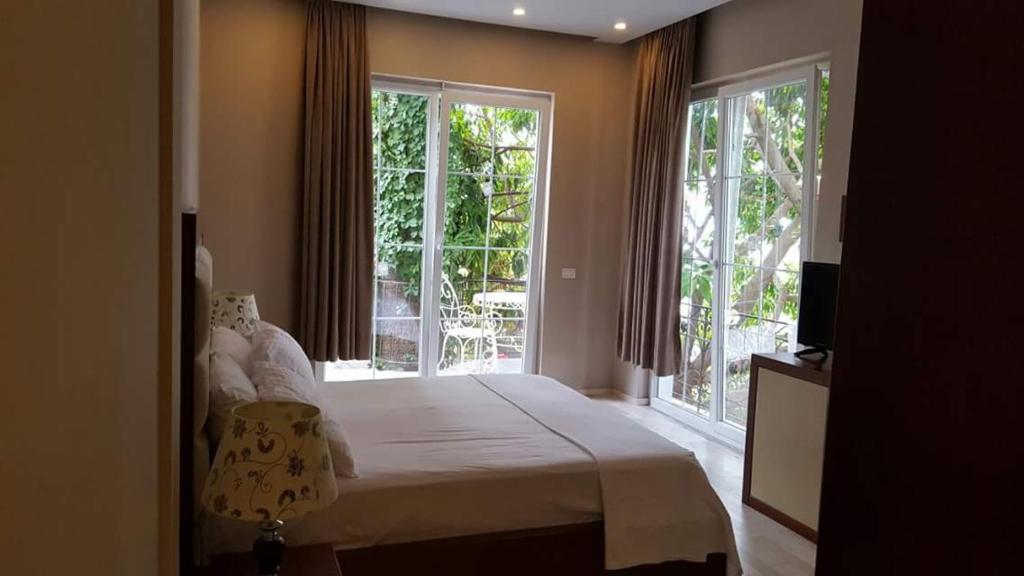 1 dormitorio con 1 cama grande y ventanas en Hotel Magllara, en Sarandë