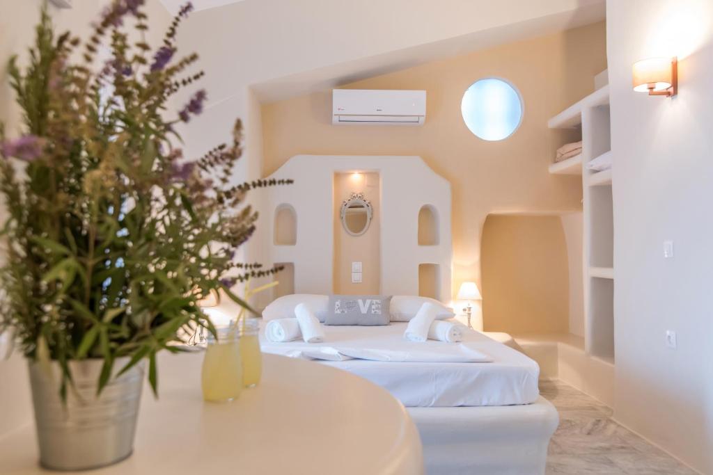 um quarto com uma cama e uma mesa com flores em Fratelli Rooms em Tinos Town