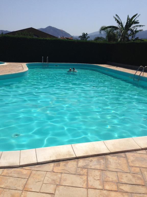 uma pessoa a nadar numa grande piscina azul em Villetta Dolce em Campofelice di Roccella