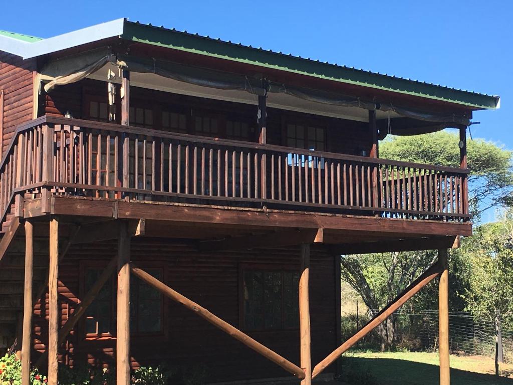 a large wooden deck on a log cabin at Bridal Drift Cottage in Colenso