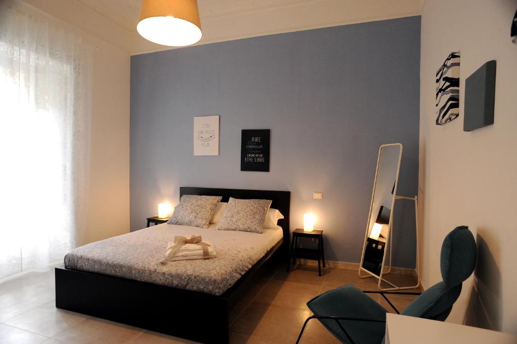 sypialnia z łóżkiem i niebieską ścianą w obiekcie Maison Salerno w mieście Salerno