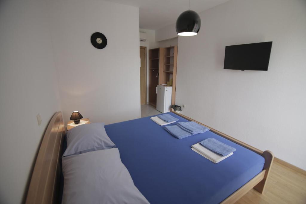 a bedroom with a blue bed with a flat screen tv at Apartments Mićić in Hvar