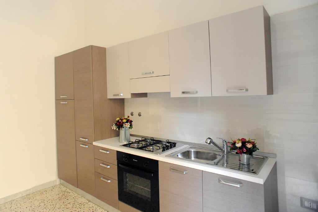 kuchnia z białymi szafkami i zlewem w obiekcie Maison Salerno w mieście Salerno