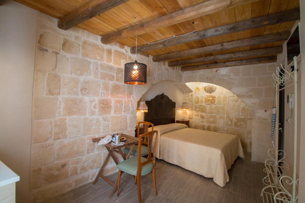 a bedroom with a bed in a stone wall at HolidayMonopoli in Monopoli