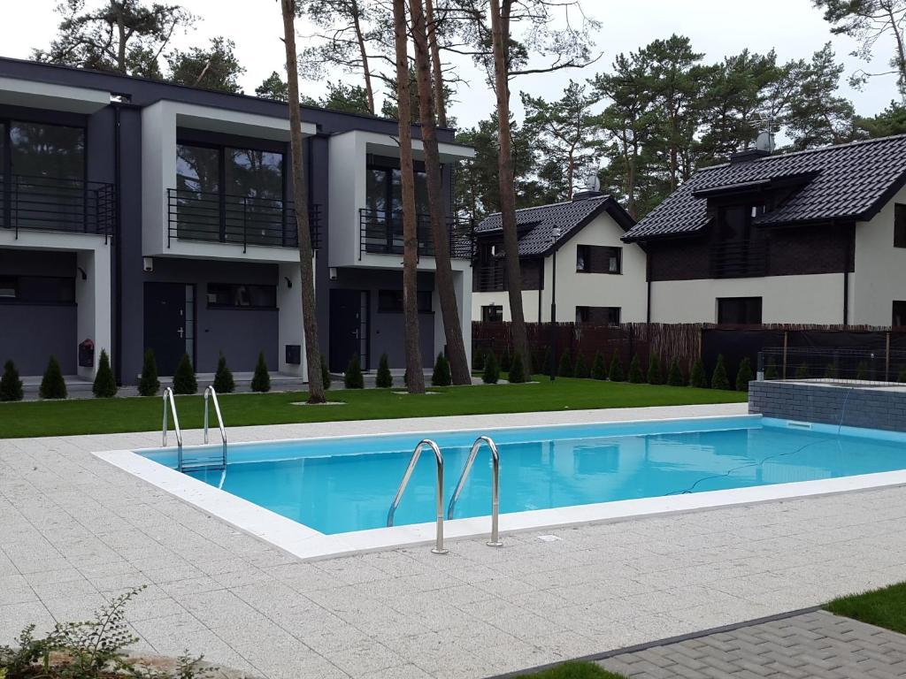 a swimming pool in front of a house at KAMI Ferienwohnungen in Pobierowo