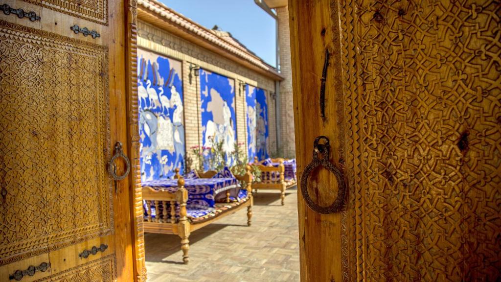 Habitación con cuadros azules y blancos en las paredes. en Hotel Caravan Serail, en Samarkand