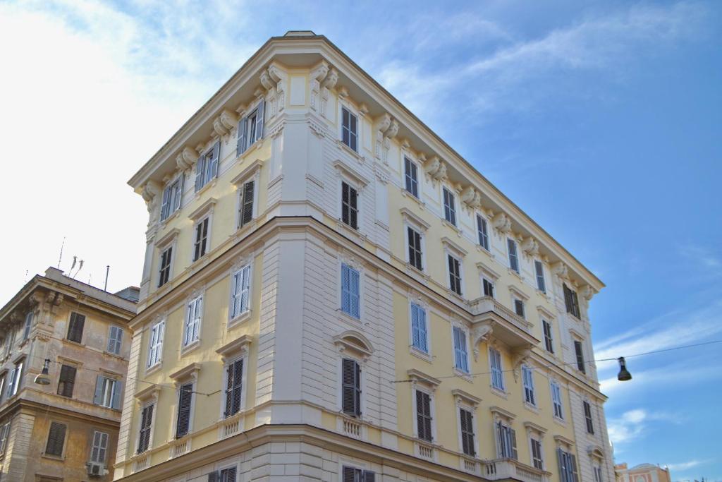 a yellow building with a clock on the top of it at Mascherino Suites in Rome