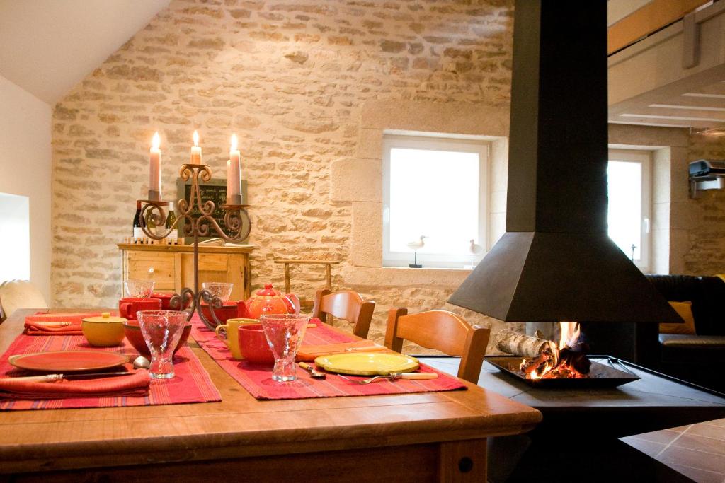 a dining room with a table and a fireplace at Gite Le Meix Chapeau in Levernois