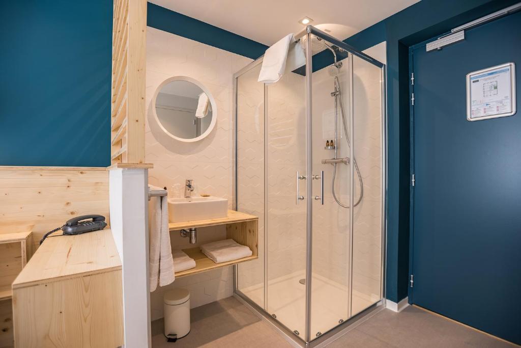 a bathroom with a shower and a sink at Hôtel Café Miramar in Le Grau-du-Roi