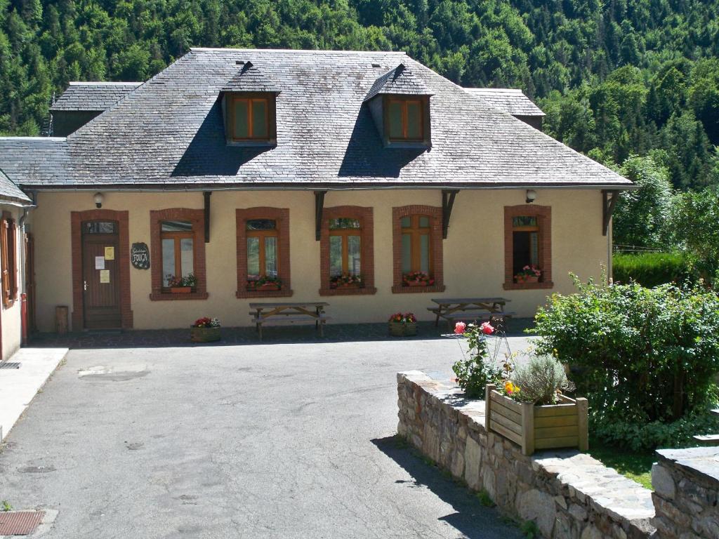 a large house with a porch and a patio at Gite Fouga in Aragnouet
