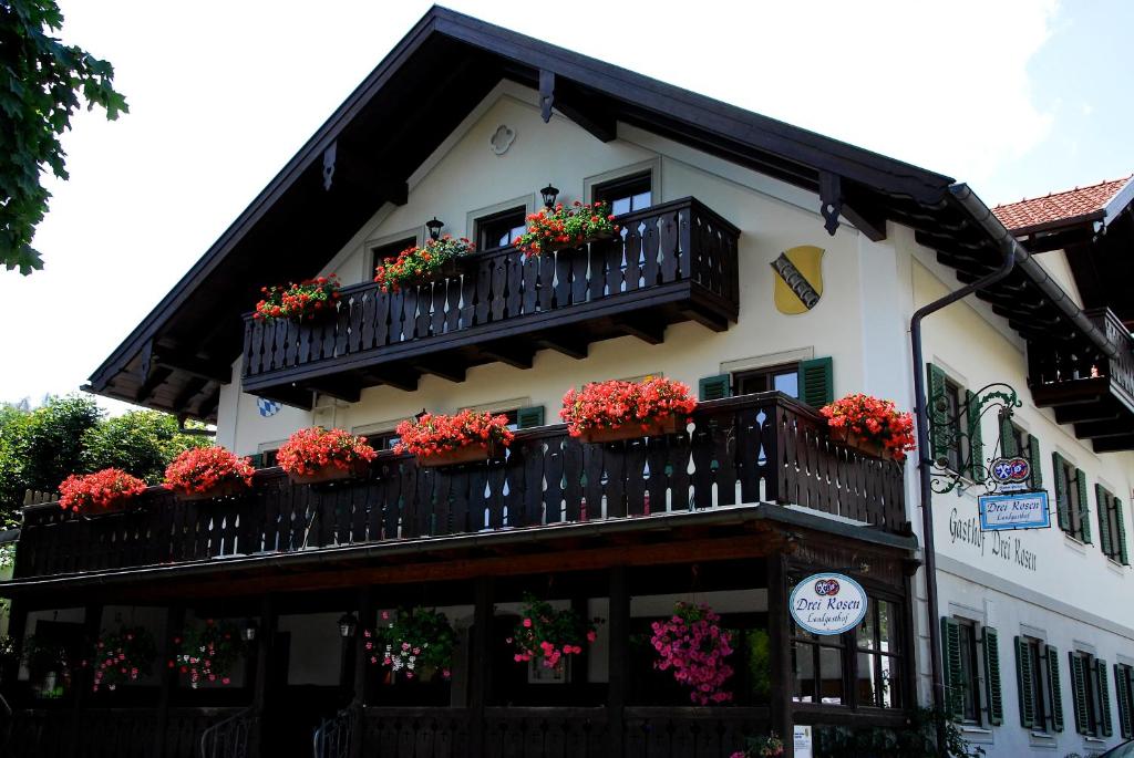 ein Gebäude mit Blumenkästen auf den Balkonen in der Unterkunft Landgasthof Drei Rosen in Bernried