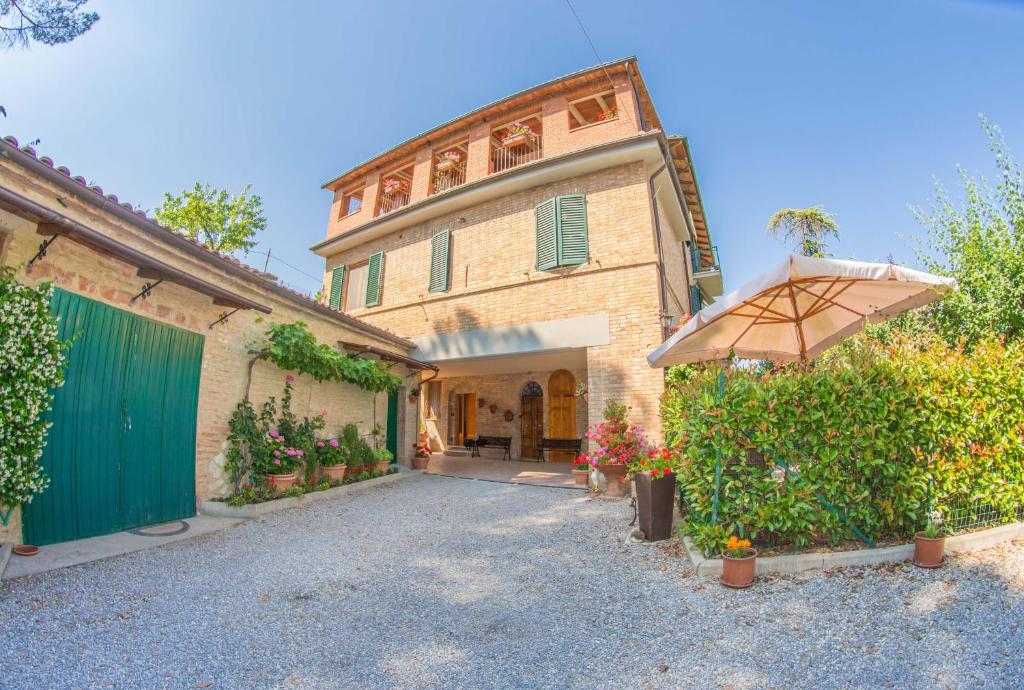 a large building with an umbrella in front of it at I Due Cipressi in Torrenieri