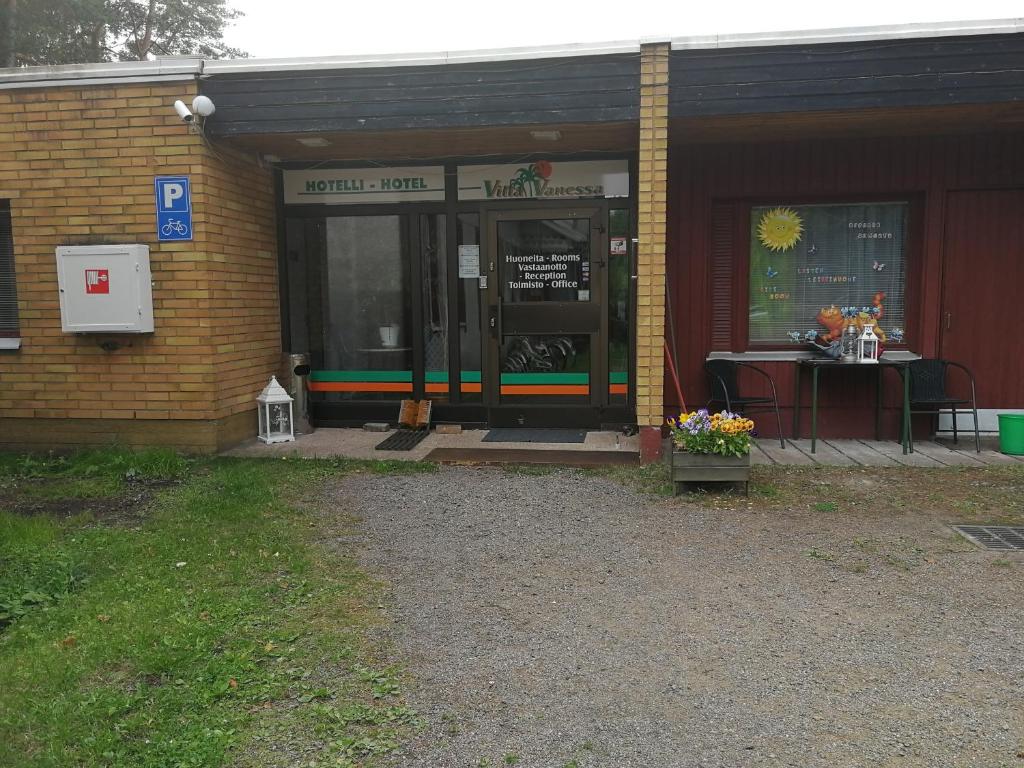 a building with a table in front of a door at Hotel Villa Vanessa in Siltakylä