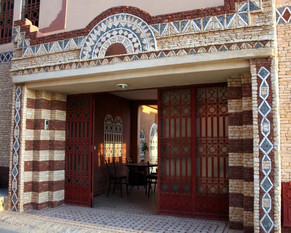 een ingang naar een gebouw met rode deuren en een tafel bij Villa Sunset B&B in Aourir