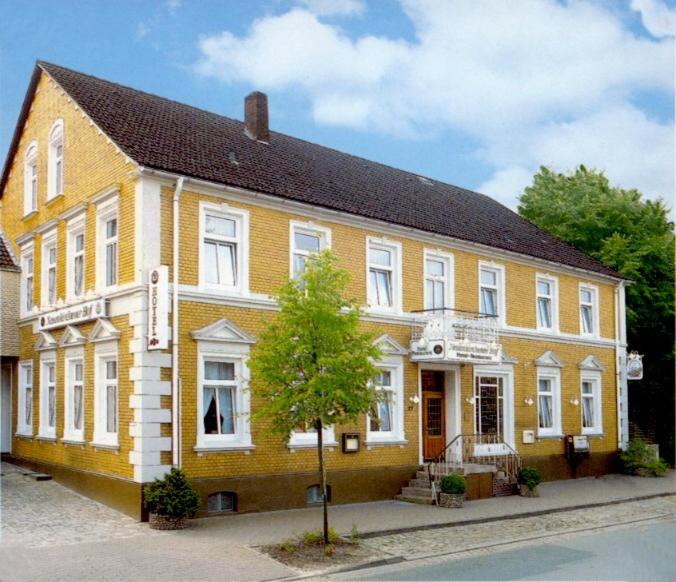 ノイエンキルヒェンにあるNeuenkirchener Hofの黒屋根の大きな黄色の建物