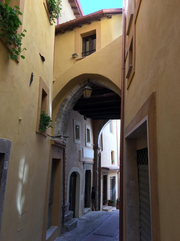 une allée avec une arche entre deux bâtiments dans l'établissement Alloggio del Grand Tour, à Sonnino