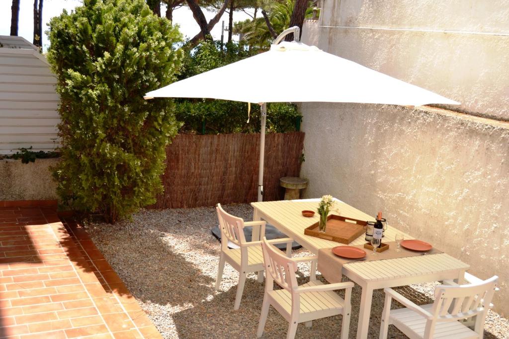 プラヤ・デアロにあるApartamento con jardín Platja d'Aroの白いテーブルと椅子