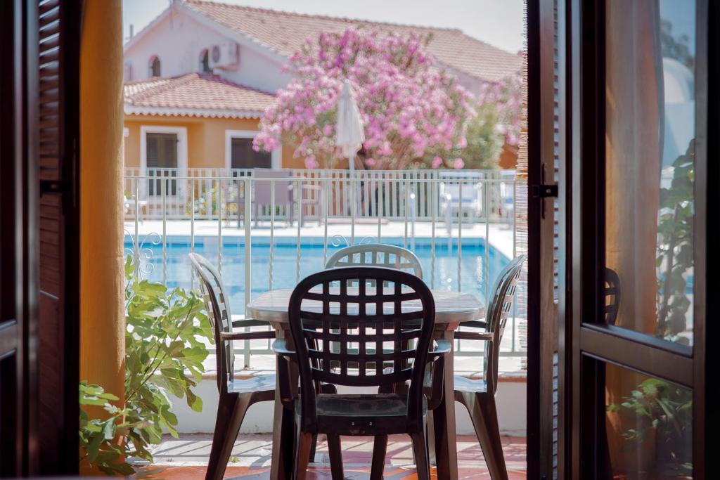 a table and chairs on a balcony with a swimming pool at Residence Verde Mare Official Site in Tortolì