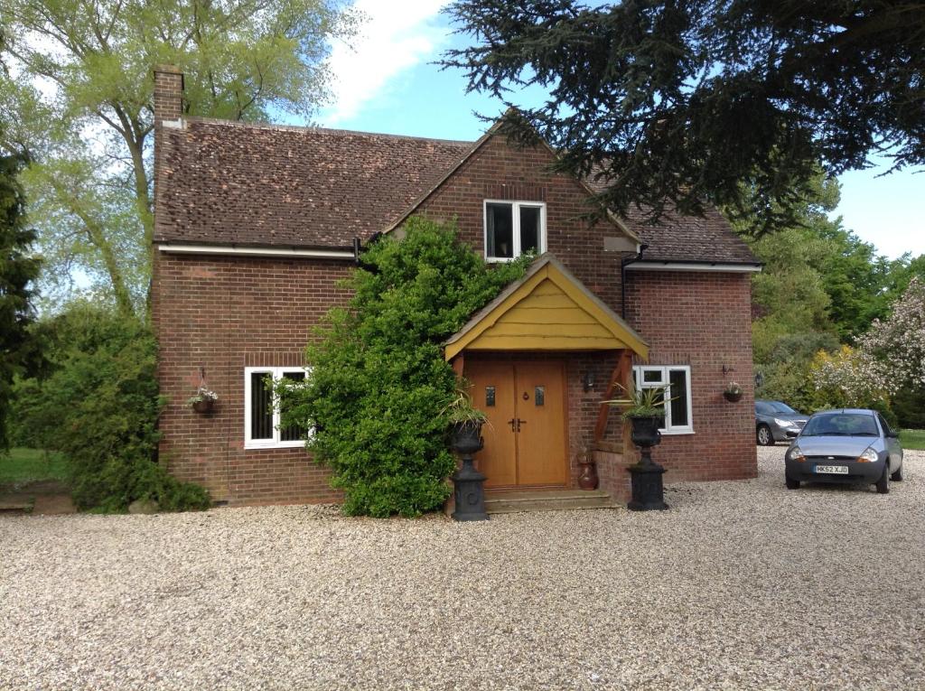 a red brick house with a yellow door at B&B Dorwyn Manor in Avebury