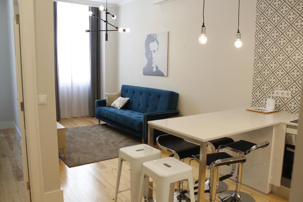 a living room with a blue couch and a table at Augusta Street 213 - 2 Dto in Lisbon