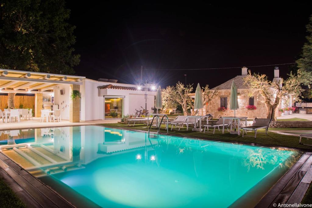 a swimming pool in front of a house at night at La linea dell'orizzonte in Alberobello