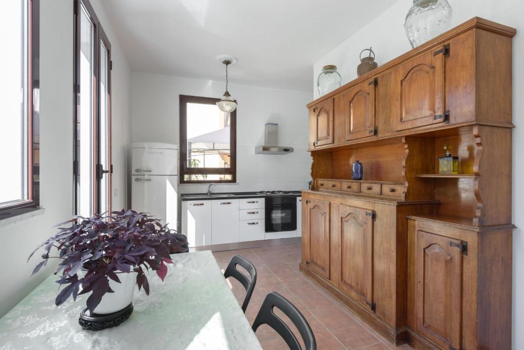 uma cozinha com armários de madeira e uma mesa com cadeiras em Cornelia Penthouse em Roma