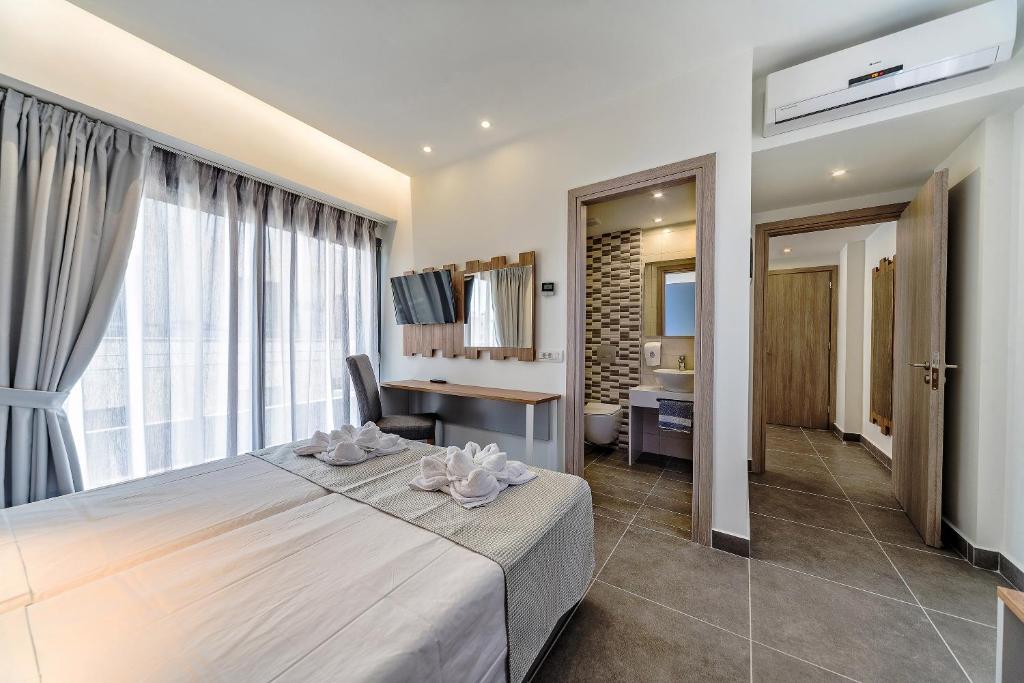 1 dormitorio con 1 cama y escritorio en una habitación en Pollis Hotel en Hersonissos