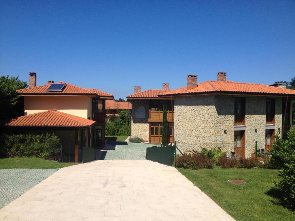 a large house with a walkway in front of it at La QuintaEsencia in La Pereda de Llanes