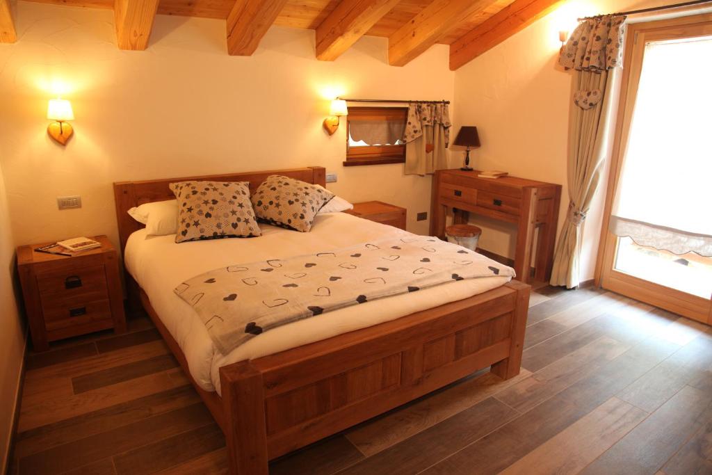 ein Schlafzimmer mit einem großen Bett und einem Fenster in der Unterkunft Mi Casa Tu Casa in Brusson