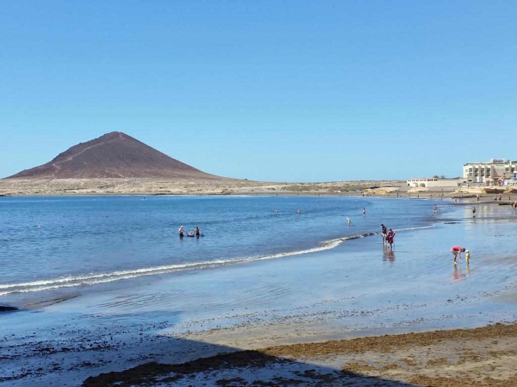 un grupo de personas en el agua en la playa en Apartamentos Medano - Mirazul 2, en El Médano
