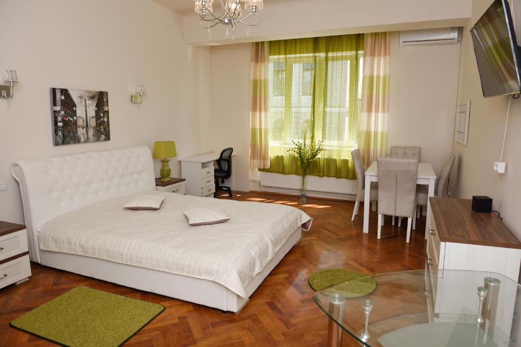 1 dormitorio con cama blanca y mesa en Modern Old Town Ap. Baritiu, en Cluj-Napoca