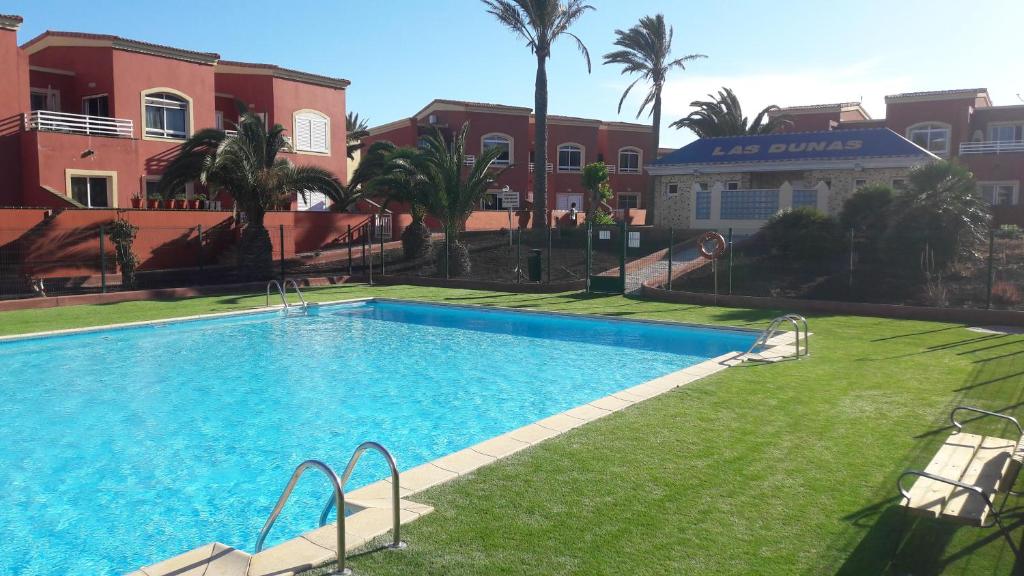 a large swimming pool in a yard next to a building at Casa Sur in Corralejo