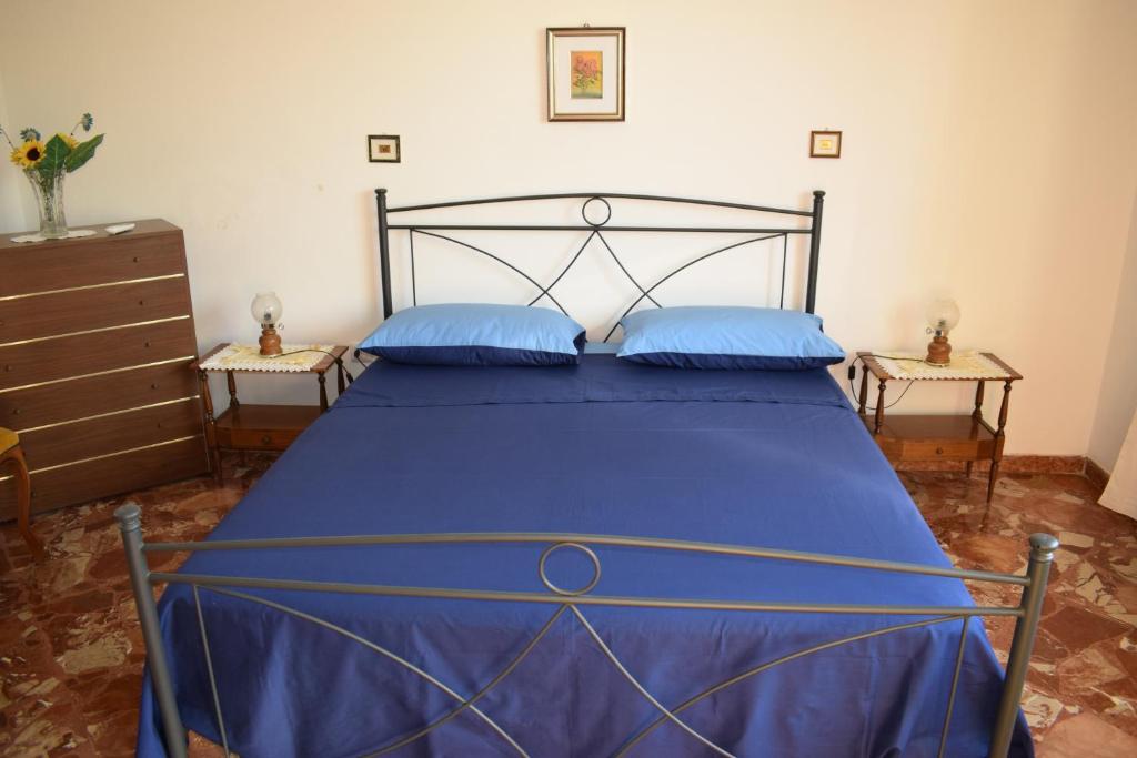 アックーアリカ・デル・カーポにあるVacanze Blu Salentoのベッドルーム1室(青いベッド1台、青い枕2つ付)