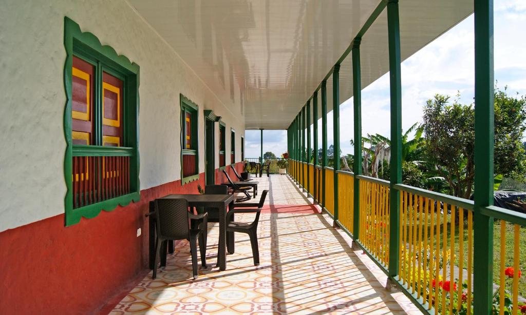 a balcony with tables and chairs on a building at Hostal Casa de Los Taitas in Salento